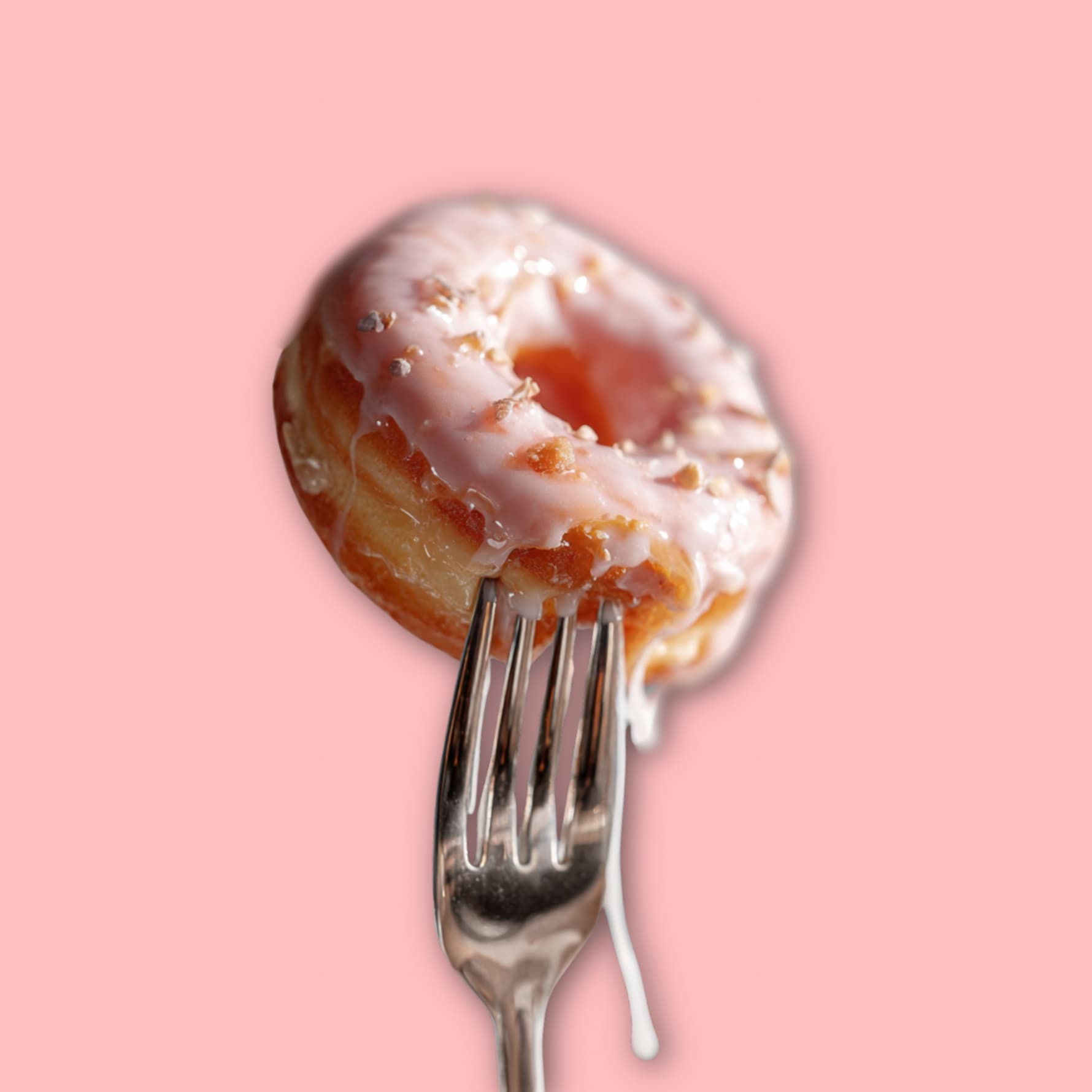 Close-up of a pink glazed donut held on a fork with icing dripping, styled on pastel pink background for Baker’s Secret About Us page.