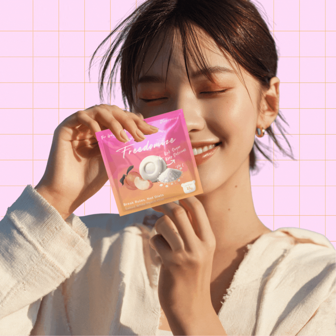 woman smiling holding freedomize peach sea salt mint sugar free packaging against pink grid background