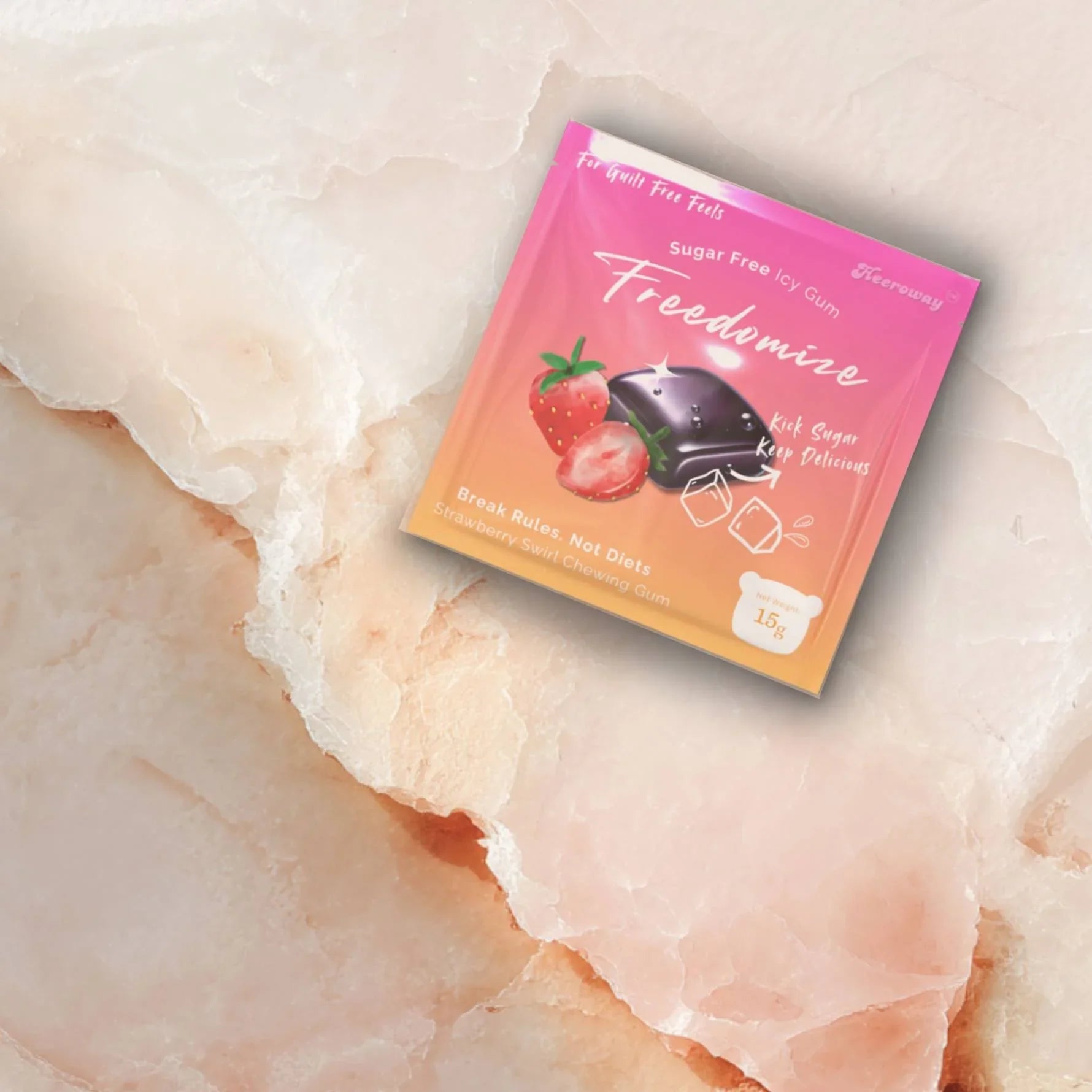 A Freedomize Strawberry Swirl Sugar Free Icy Gum pouch placed on a light pink marble surface.