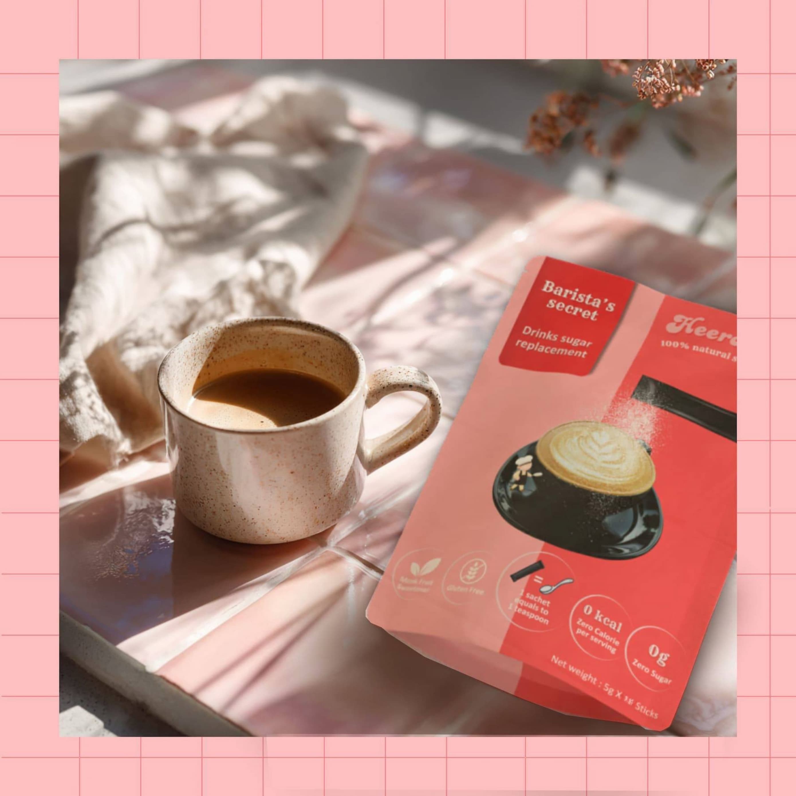 barista’s secret drink sweetener by heeroway next to warm coffee cup on pink tiled table.