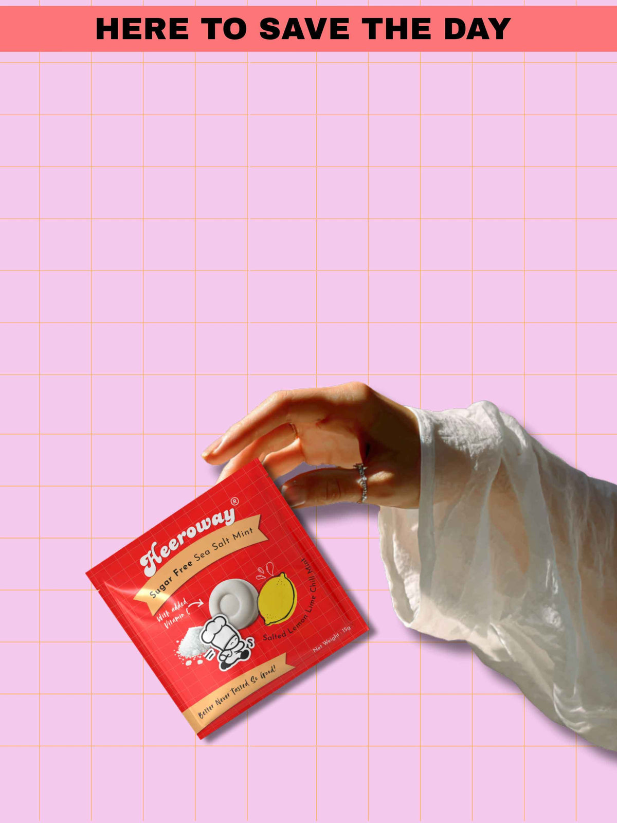 hand holding Heeroway sea salt mint sugar free packaging with lemon and mint design on pink grid background and text here to save the day for mobile mode