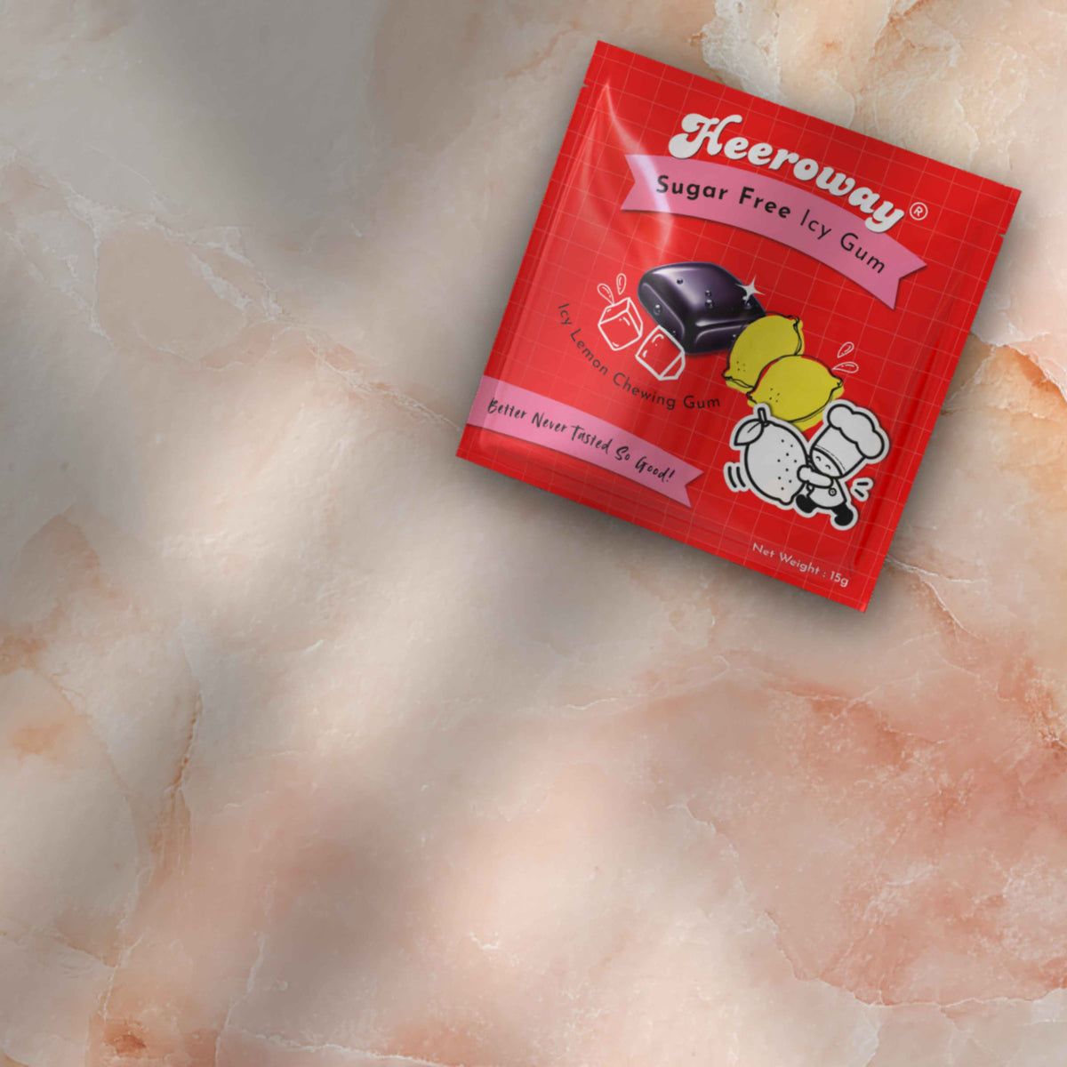 A packet of heeroway Sugar Free lemon Icy Gum placed diagonally on a textured beige and pink marble surface.
