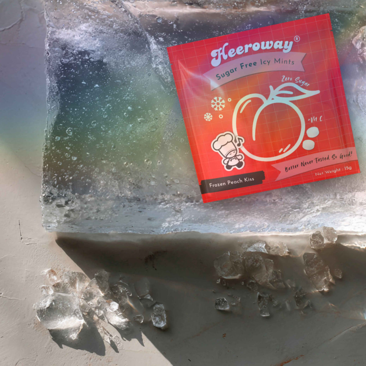 A packet of Heeroway Frozen Peach Kiss flavor placed on top of a clear ice block with ice crystals scattered around it on a neutral surface.