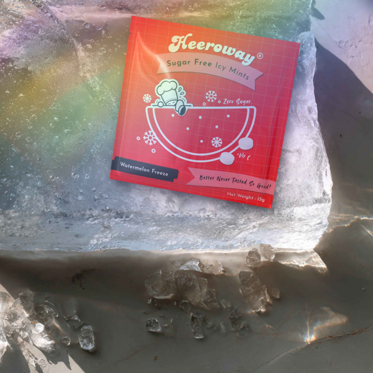A red packet of Heeroway Sugar Free Icy Mints, watermelon flavor, placed on top of a large ice block with scattered ice crystals on a gray stone surface.