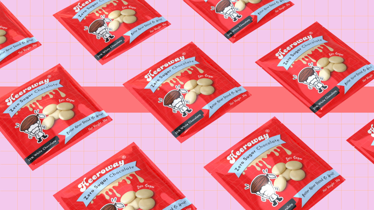 Multiple packets of heeroway white chocolate pouch  arranged diagonally on a pink grid background. 