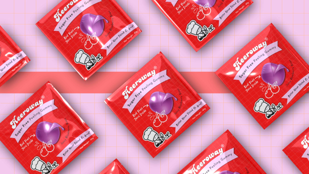 Multiple Heeroway blueberry peeling gummy arranged diagonally on a pink grid background.
